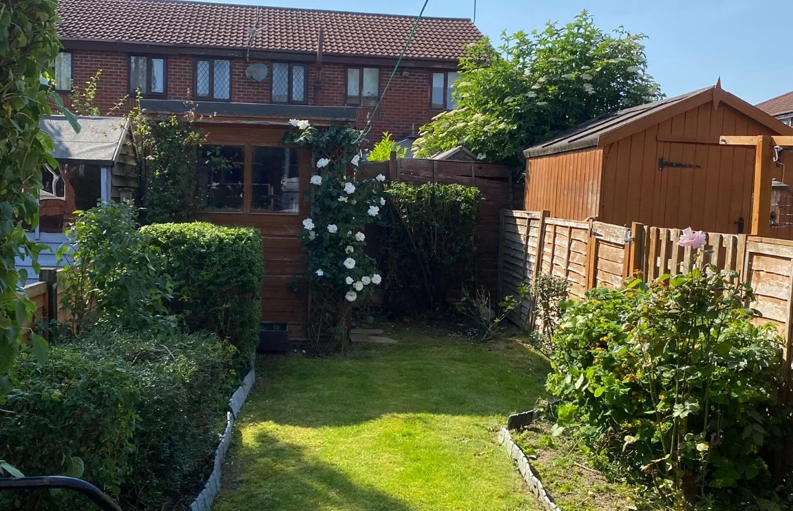 Genuine photograph of a tidy residential garden with lawn and borders